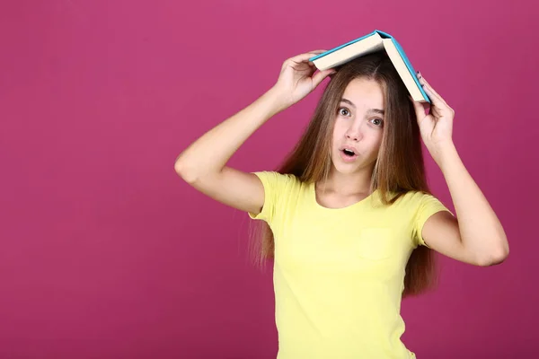 Jovencita Sosteniendo Libro Cabeza Sobre Fondo Rosa — Foto de Stock