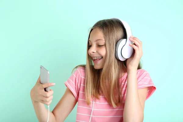 Vakker Ung Jente Med Hodetelefoner Smarttelefon Mintbakgrunn – stockfoto