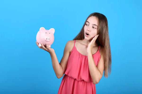 Ung Flicka Håller Rosa Piggybank Blå Bakgrund — Stockfoto