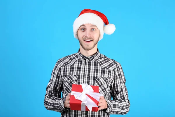 Young Man Santa Hat Holding Gift Box Blue Background — Stock Photo, Image