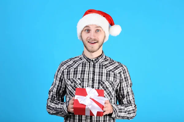 Jeune Homme Santa Chapeau Tenant Boîte Cadeau Sur Fond Bleu — Photo