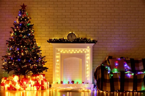 白色装饰的壁炉靠近圣诞树和沙发在砖墙背景 — 图库照片