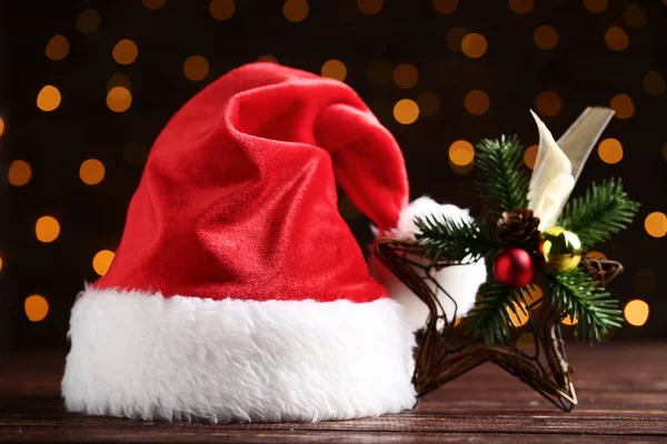 Santa claus hat with decorative star on bokeh lights background