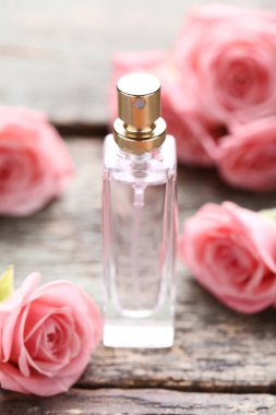 Parfüm şişesi ile gül ahşap masa üzerinde