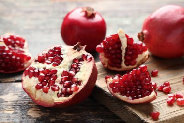 Olgun ve sulu nar ile kesme tahtası üzerinde gri ahşap masa