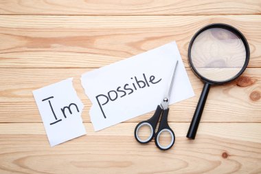 Word imkansız, makas ve ahşap masa üzerinde büyüteç ile kağıt