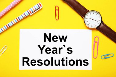 Yeni yıl kararları kağıt kalem, kol saati ve renkli klibi ile üzerine