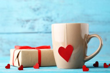 Çay ahşap masa üzerinde kırmızı kalpler ve hediye kutusu