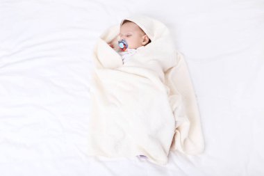 Evde yatakta uyurken emzik ile şirin bebek