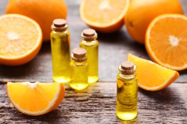 Gri ahşap masa üzerinde şişelerde portakal yağı