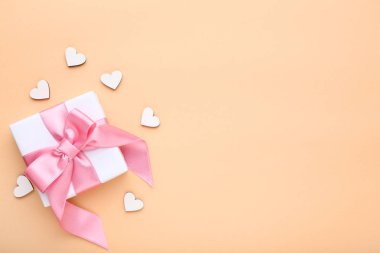 Bej renkli arka plan üzerinde küçük beyaz yürekleri hediye kutusu