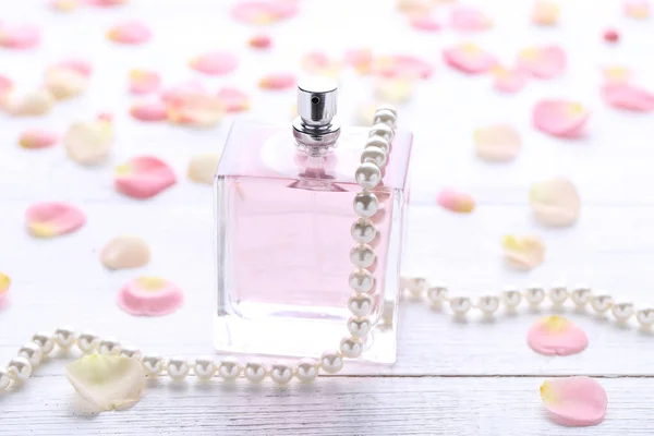 Botella Perfume Con Pétalos Flores Perlas Sobre Mesa Madera — Foto de Stock