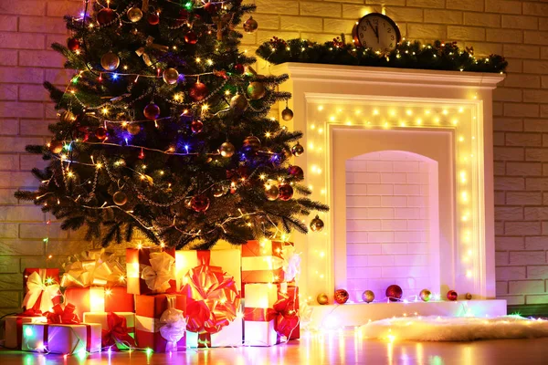 Camino Decorato Illuminato Vicino Albero Natale Sfondo Muro Mattoni — Foto Stock