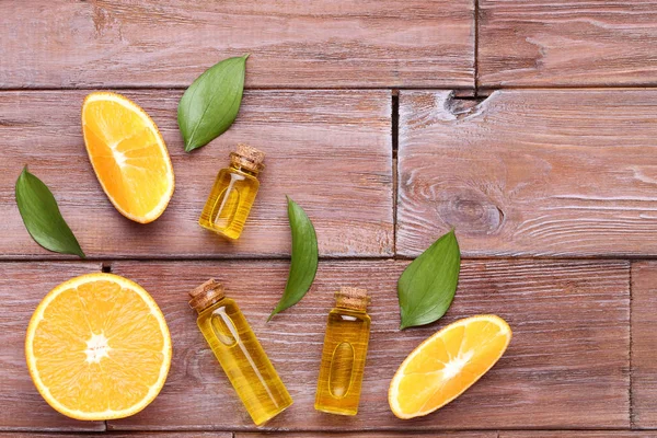 Orangenöl Flaschen Mit Grünen Blättern Auf Braunem Holztisch — Stockfoto