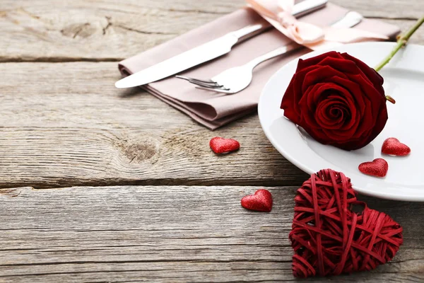 木製テーブルの上のプレートに赤いバラを持つキッチン カトラリー — ストック写真