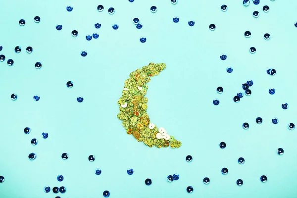 Round sequins in moon shape on mint background