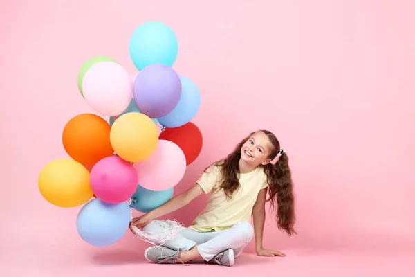 Menina Bonito Com Balões Coloridos Sentado Fundo Rosa — Fotografia de Stock