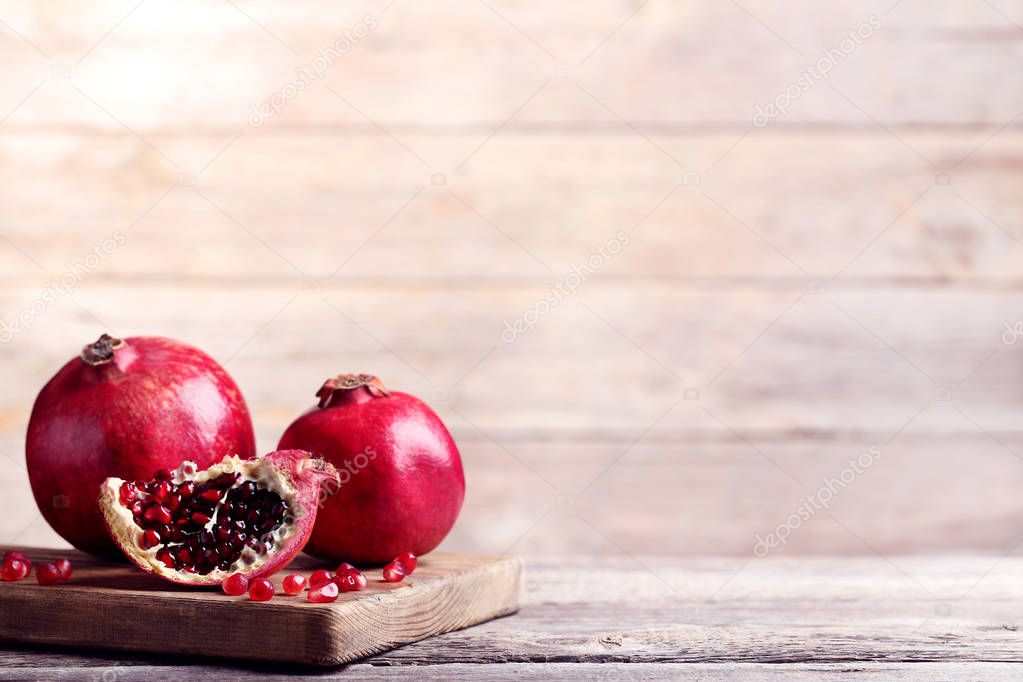 Ripe and juicy pomegranate on wooden cutting board