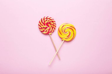 Pembe bir arka plan üzerinde renkli lolipop