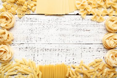 Beyaz ahşap masa üzerinde farklı pişmemiş makarna