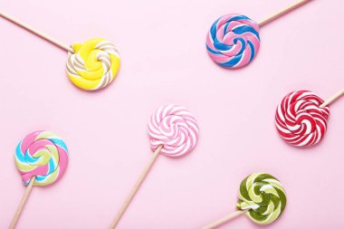 Pembe bir arka plan üzerinde renkli lolipop