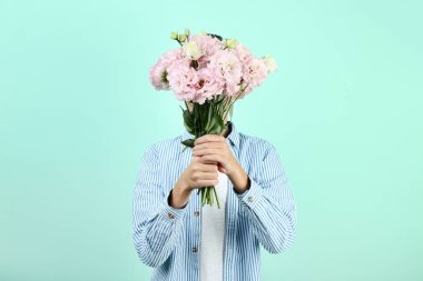 Nane arka plan üzerinde eustoma çiçekli genç çocuk