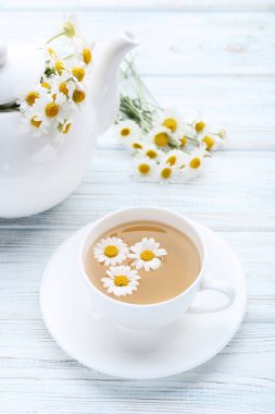 Ahşap masa üzerinde papatya çiçeği ile çay