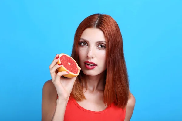 Schöne Rothaarige Frau Mit Grapefruit Auf Blauem Hintergrund — Stockfoto