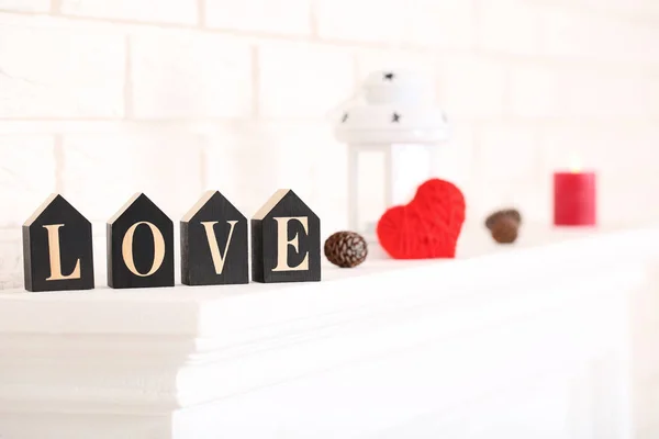 词爱与锥体和红色心脏在白色壁炉 — 图库照片