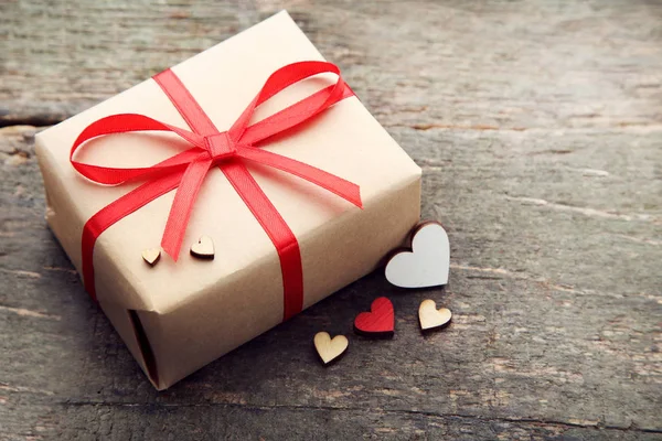 Hediye kutusu ahşap masa üzerinde yürekleri