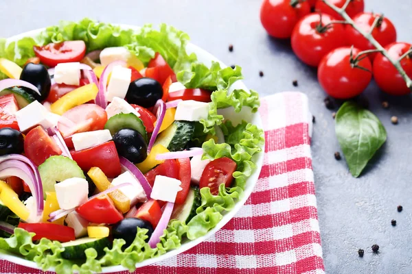 Gri arka plan üzerinde kırmızı peçete kase sebze salatası