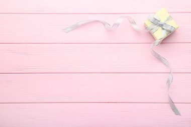 Hediye kutusu ile şerit pembe ahşap masa üzerinde