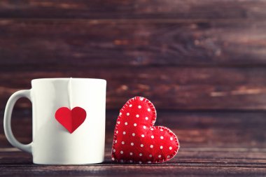 Sevgililer kumaş kalp ve kahverengi ahşap tabloda çay poşeti fincan