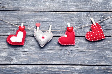 Üzerinde gri ahşap arka plan asılı kumaş kalpler