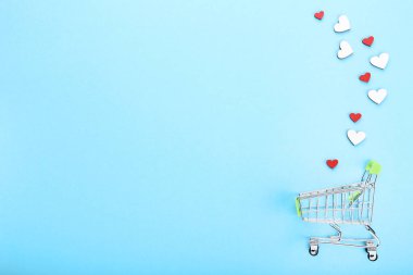 Mavi arka plan üzerinde kırmızı ve beyaz yürekleri alışveriş sepeti