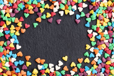 Sprinkles siyah arka plan üzerinde renkli kalp şeklinde