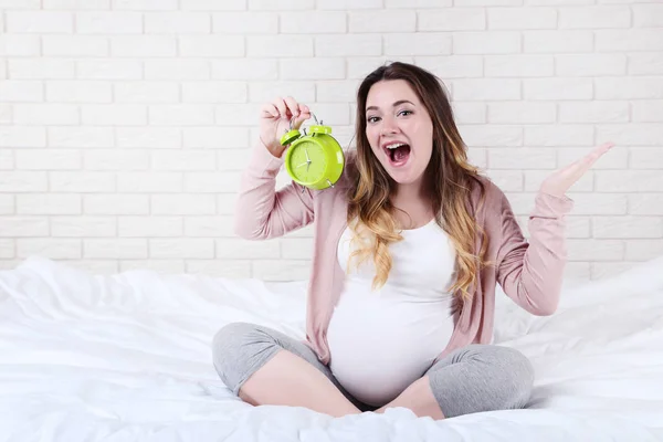 Mooie Zwangere Vrouw Met Wekker Zittend Bed — Stockfoto