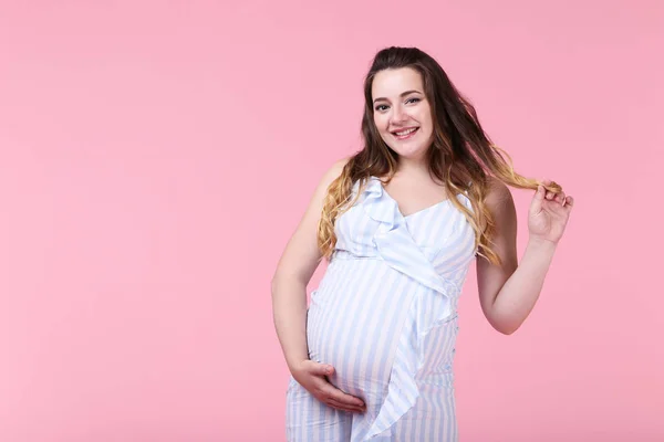 Mooie Zwangere Vrouw Gestreepte Jurk Roze Achtergrond — Stockfoto