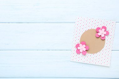 Ahşap masaya kağıt çiçek ile el yapımı tebrik kartı