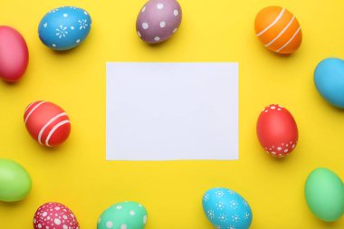 Kağıt üzerinde sarı arka plan boş levha ile renkli Paskalya yumurtaları