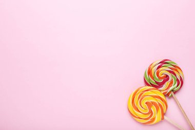 Pembe bir arka plan üzerinde renkli lolipop