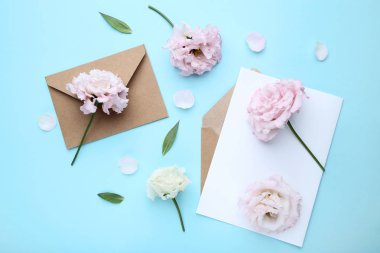 Zarf ve kağıt üzerinde mavi arka plan ile Eustoma çiçekler