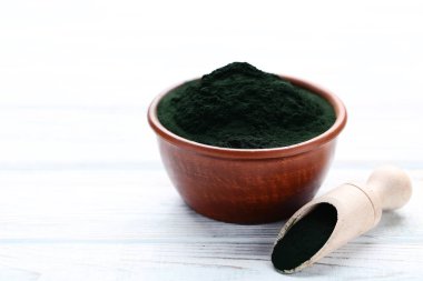 Spirulina toz kase ve ahşap masa üzerinde kepçe