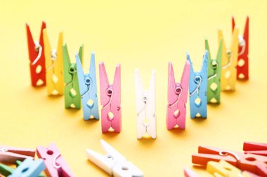 Sarı arka plan üzerinde renkli clothespins dönüştürün