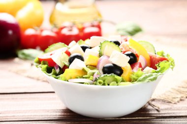 Kahverengi ahşap masa üzerinde kase sebze salatası