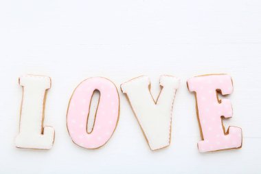 Beyaz ahşap masa üzerinde ev yapımı kurabiye tarafından kelime aşk
