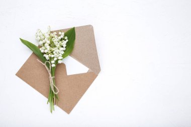 Beyaz arka plan üzerinde zarf çiçeklerle Lily vadi