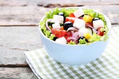 Ahşap masa peçeteye kase sebze salatası