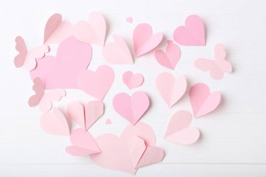 Kağıt Kalpler pembe ve beyaz tahta masada kelebek