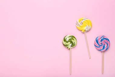 Pembe bir arka plan üzerinde renkli lolipop